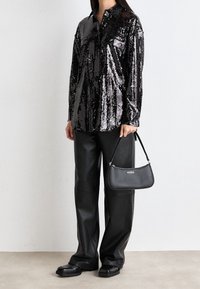 Black sequined shirt with a button-up front, paired with loose black leather pants. Holding a black handbag with "HUGO" logo. Black shoes.