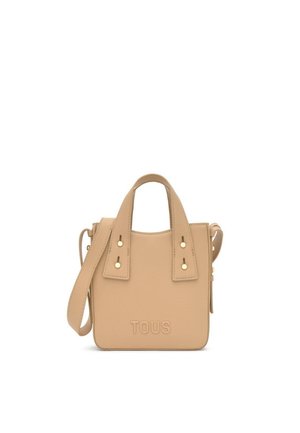 Bolso de mano Tous beige con asas cortas, una correa larga para el hombro, tachuelas en tono dorado y logotipo grabado en relieve, sobre un fondo blanco.
