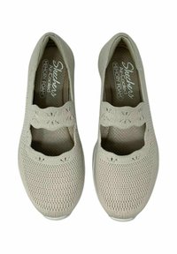 Zapatos Skechers de color gris claro, fabricados con tela de malla y un diseño transpirable. Presentan una puntera redondeada y una tira estampada que cruza el empeine.