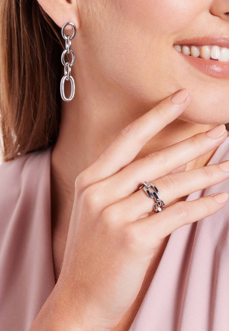 Zilveren kettingoorringen en een bijpassende ring. De oorringen hebben langgerekte schakels; de ring heeft een bicolor ontwerp met gepolijste accenten.
