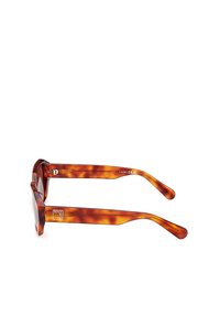Ochelari de soare tortoise brown cu ramă groasă, rotundă și temple înguste. Prezintă detalii cu logo și un finisaj neted din plastic.