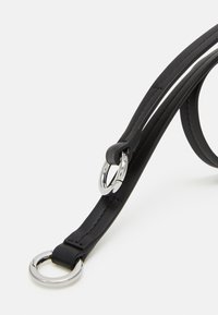 Czarny pasek ze skóry z srebrnymi elementami, płaskim designem i okrągłymi pierścieniami. Materiał jest gładki, z wyraźnymi detalami szycia.