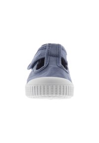 Scarpa in tela blu con sole in gomma bianca, caratterizzata da due sezioni ritagliate e una sola fascia per un fissaggio sicuro. Dettagli in tessuto testurizzato.
