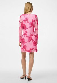 Vestido de chiffon rosa con mangas largas, que presenta bordados florales en un tono de rosa más oscuro. El dobladillo está ligeramente por encima de la rodilla, y el diseño transparente realza la textura.