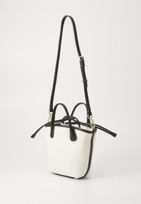 Väike ristkülikukujuline käsikott beežist kangast mustade nahkaaktsentidega. Omab kahte ülemist käepidet ja eemaldatavat, reguleeritavat rihma. Kuldne riistvara.