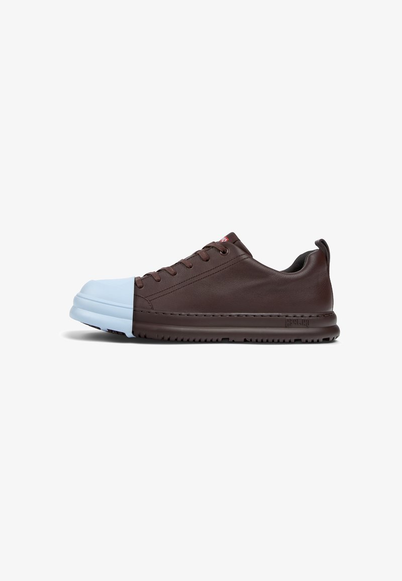 Brown leather sneaker with a blue rubber toe cap, low profile design, six eyelets, and textured sole. Features red branding on the tongue.