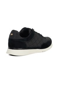 Black suede sneaker with quilted texture, a white sole, and gold logo detail on the heel. Features a smooth upper and lace closure.