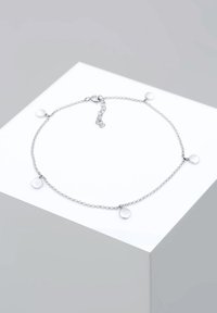 Silberne Kettenarmband mit runden Akzentanhängern, verbunden durch kleine runde Verbinder, auf einer glatten, polierten Oberfläche.