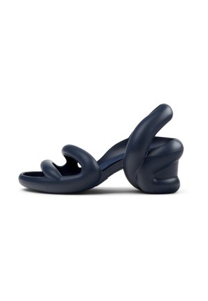 Navy blue high-heeled sandals with a wavy, sculptural design; made of smooth material; features open toe and curved straps.