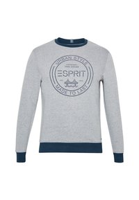 Sweat-shirt gris à manches longues avec un col rond côtelé bleu marine. Présente un logo circulaire bleu marine au centre et des poignets assortis.