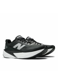 Baskets de sport noires avec dessus en tissu en maille, logo blanc prominent, conçues avec un motif texturé et une semelle intermédiaire blanche incurvée pour l'amorti.