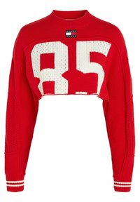 Červený zkrácený svetr s bílou grafikou "85". Má žebrovaný kulatý výstřih, dlouhé rukávy a strukturované pletené detaily na bočních panelech. Součástí je značka.