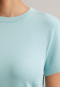 Lichtblauw kortemouwenshirt van een textuur, ademende stof, met een ronde halslijn en een relaxte pasvorm, geschikt voor casual dragen.