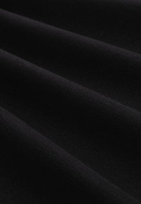Schwarzer Stoff mit einer gerippten Textur, der weiche, horizontale Falten zeigt. Das Material wirkt dehnbar und glatt und deutet auf Langlebigkeit und Komfort hin.