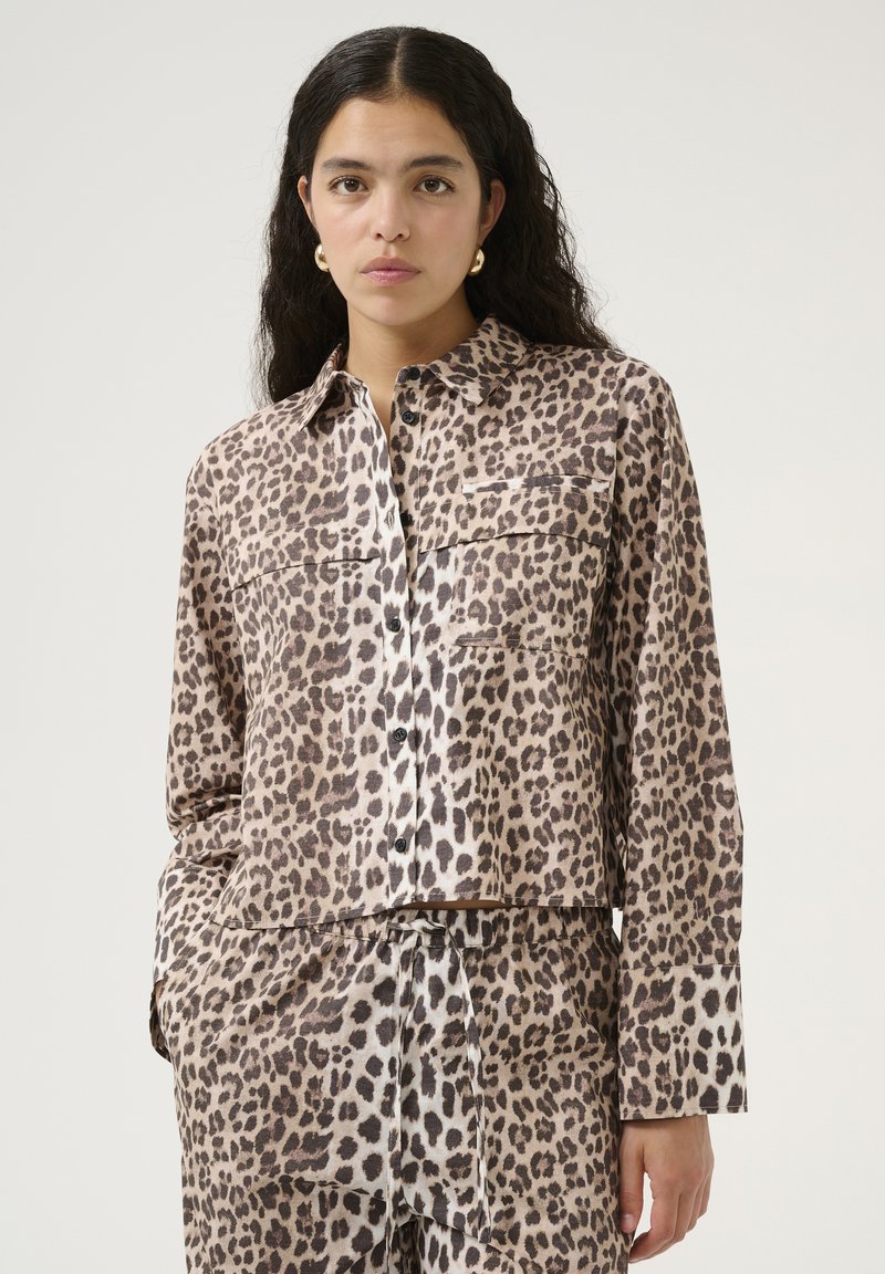 Leopardprint blouse met lange mouwen van een zachte stof, met een knoopsluiting aan de voorkant, twee borstzakken en een cropped ontwerp.
