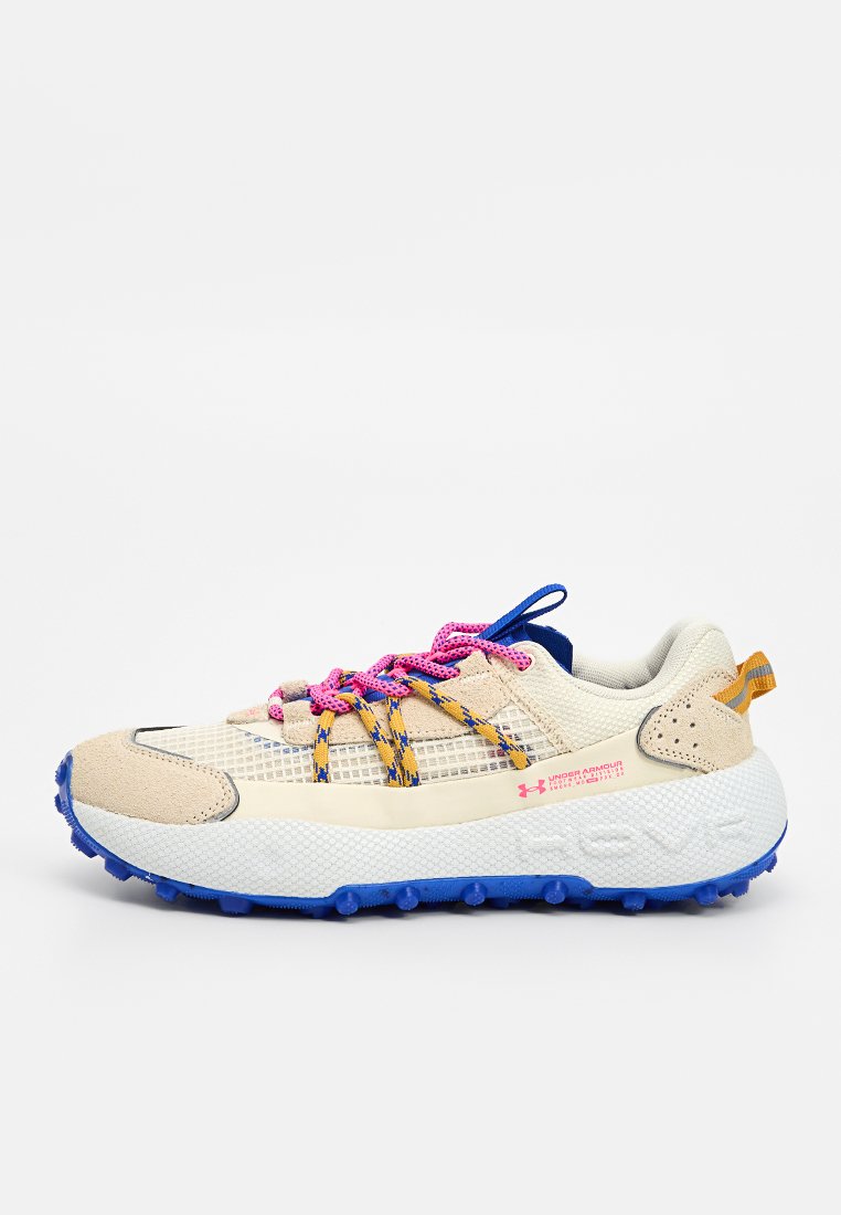 Zapatilla atlética beige con parte superior de malla, suela de goma azul vibrante y cordones rosa/azul. Cuenta con una puntera texturizada y un acento amarillo.