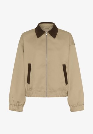 Bež jakna s ovratnikom od smeđeg manšestra, patentnim zatvaračem sprijeda i elastičnim strukom. Ima dva smeđa manšestrena bočna džepa.