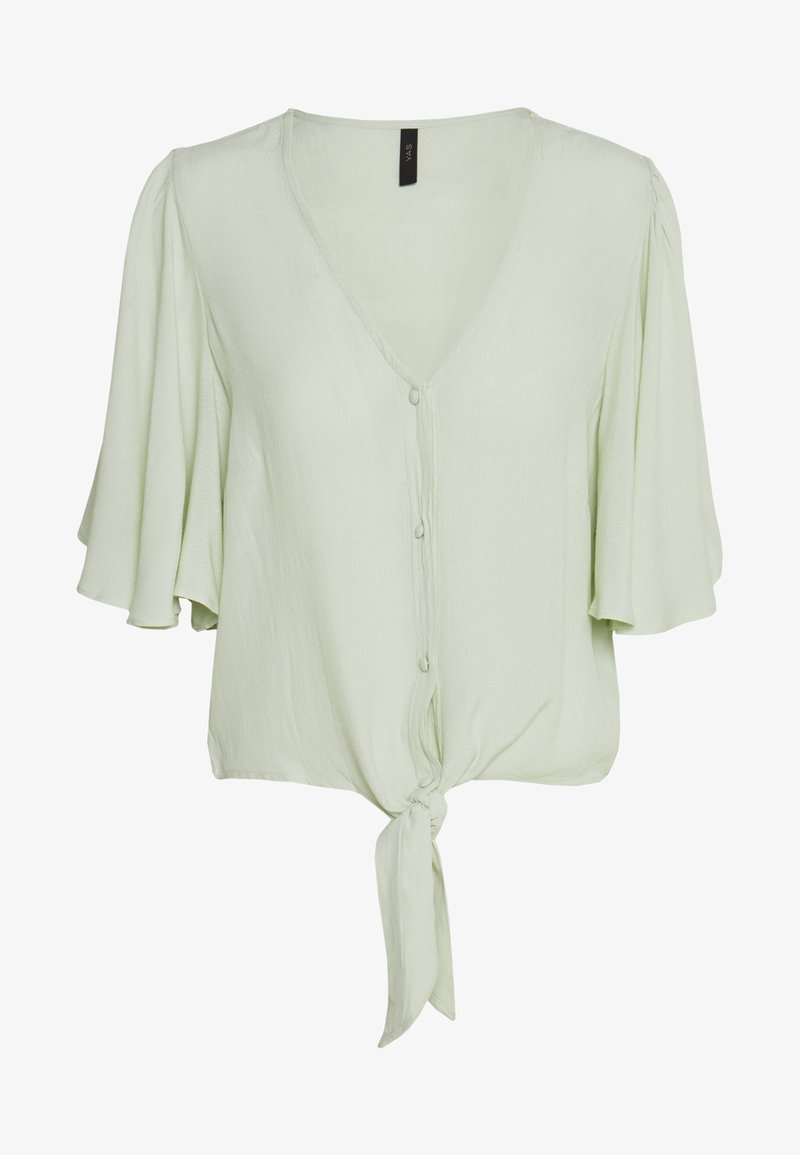 Blouse vert clair avec col en V, manches courtes évasées, boutons devant et détail d'un nœud noué à l'ourlet.