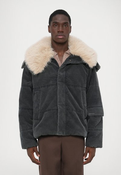 Grå kordfløjljakke med en beige faux fur-krave, der har en boxy form, store lommer og knappelukning. Glat overflade og syede detaljer.