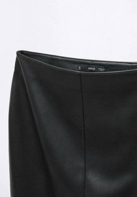 Musta keinonahkainen hame, jossa on sileä pinta, korkea vyötärö ja sauma-yksityiskohtia. Merkkilappu näkyvissä sisältä.