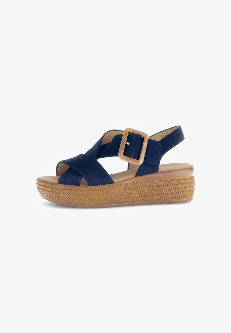 Navy suede sandal with crossed straps and adjustable buckle. Platform sole features woven texture, offering a natural look.