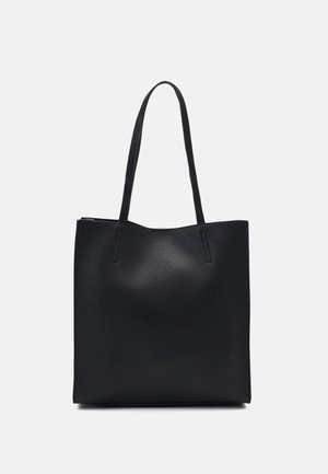 Black leather tote bag with two long straps and a smooth textured surface, standing upright against a plain light background.