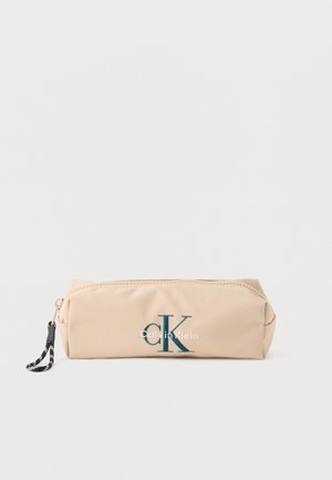 Ορθογώνια μπεζ θήκη με φερμουάρ, με μαύρο και άσπρο λουράκι στο φερμουάρ και σκούρο πράσινο λογότυπο "CK Calvin Klein" στο μπροστινό μέρος.