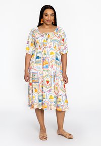 Kurzärmeliges, mittellanges Kleid mit einem bunten, tropischen Obst- und Reise-Motiv auf weißem Hintergrund. Leichter Stoff.