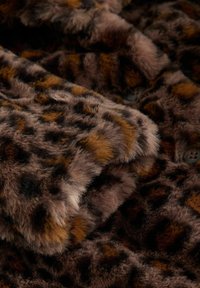 Tissu en fausse fourrure marron avec un motif léopard. Présente une surface douce et texturée avec des accents marron foncé et clair et des bords arrondis.