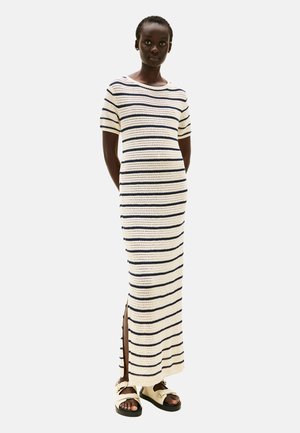 Robe en tricot au crochet crème avec des rayures navy, dotée d'un col rond, de manches courtes et de fentes latérales pour faciliter le mouvement.