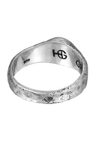 Silver ring med texturerad yta, med en vågig design och ingraverade markeringar på insidan. Slät finish och naturlig metallisk glans.