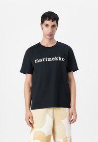 Juodas medvilninis T-shirt su baltoje spalvoje užrašu "marimekko", klasikinio apvalaus kaklo ir trumpomis rankovėmis.