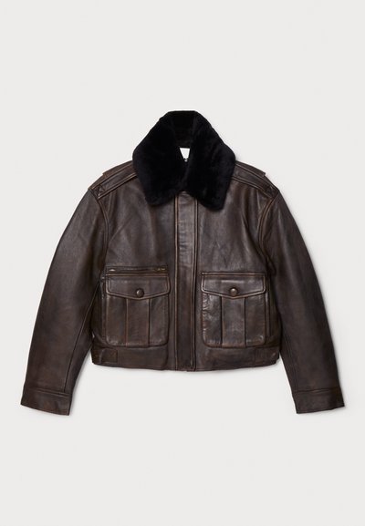 Giacca di pelle marrone con collo in pelliccia nera, chiusura con zip, due ampie tasche a patta, design su misura e finitura testurizzata.