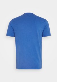 T-shirt en coton bleu avec un col rond et des manches courtes. Le tissu semble lisse, sans motifs ni embellissements.