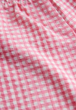 Tessuto a quadri rosa e bianco con un aspetto tessuto e strutturato, caratterizzato da un motivo a scacchi di piccoli quadrati.
