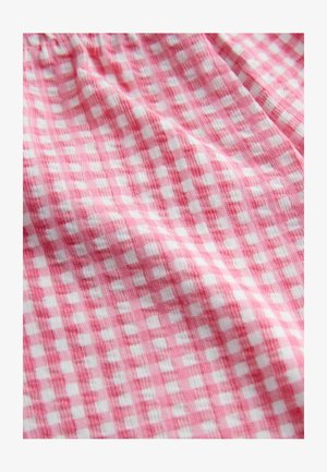 Rožinė ir balta gingham medžiaga su tekstūruota, audinio išvaizda, turinti kvadratų raštą.