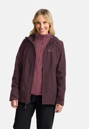 Wasserdichte Außenjacke in tiefem Pflaumenlila mit einem Reißverschluss vorne, Kapuze und verstellbaren Bündchen. Darunter liegt eine weiche, leichtere Fleece-Innenjacke in Pflaumenlila.
