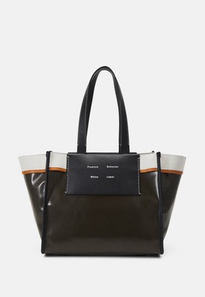 Stor tote-taske med sorte, hvide og brune paneler, dobbelte sorte håndtag og en forlomme med hvid tekstlogo.