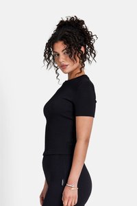 Sort kortærmet top med et tekstureret vaffelstrik-mønster. Tætsiddende design, rund udskæring og diskret sømdetalje langs kanten.