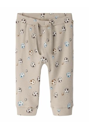 Beige ribbed baby pants with elastic waistband and drawstring, covered in small brown, blue, and black soccer ball prints.