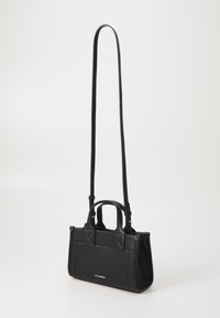 Černá texturovaná kabelka s dvojitými rukojeťmi, dlouhým nastavitelným popruhem a úhlovými detaily na bocích. Disponuje hladkým povrchem a detaily s logem.