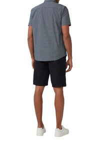 Korte mouwen, overhemd met knopen in blauw met een gestructureerd patroon, gecombineerd met donkere shorts en witte sneakers. Zichtbare details aan de achterkant zijn een yoke.