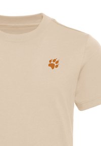 Μπεζ κοντομάνικο μπλουζάκι με μικρό καφέ αποτύπωμα πατημασιάς αρκούδας στο πάνω αριστερό μέρος του στήθους.