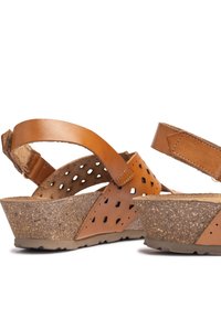 Sandalias de cuña de cuero marrón con diseño perforado, plantilla de corcho, correa ajustable y suela texturizada para un mejor agarre.