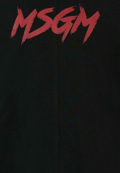 Zwarte kleding met in graffiti-stijl gedurfde, rode "MSGM" logo. Zachte textuur en minimalistische vormgeving; zichtbare stiksel details.