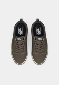 Brown canvas sneakers with white accents, rounded toes, and lace-up design. Features Vans logo on tongue and black inner lining.
