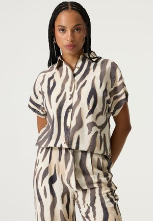 Kurzärmeliges Hemd zum Knöpfen in hellem Beige mit schwarzen und braunen Tigerstreifen, mit lockerem Schnitt und leicht verkürztem Design.
