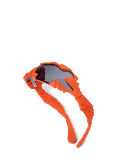 Orangene Sonnenbrille mit flammenförmigen Fassungen und dunklen Gläsern, mit strukturierten Flammendesigns an den Bügeln vor weißem Hintergrund.
