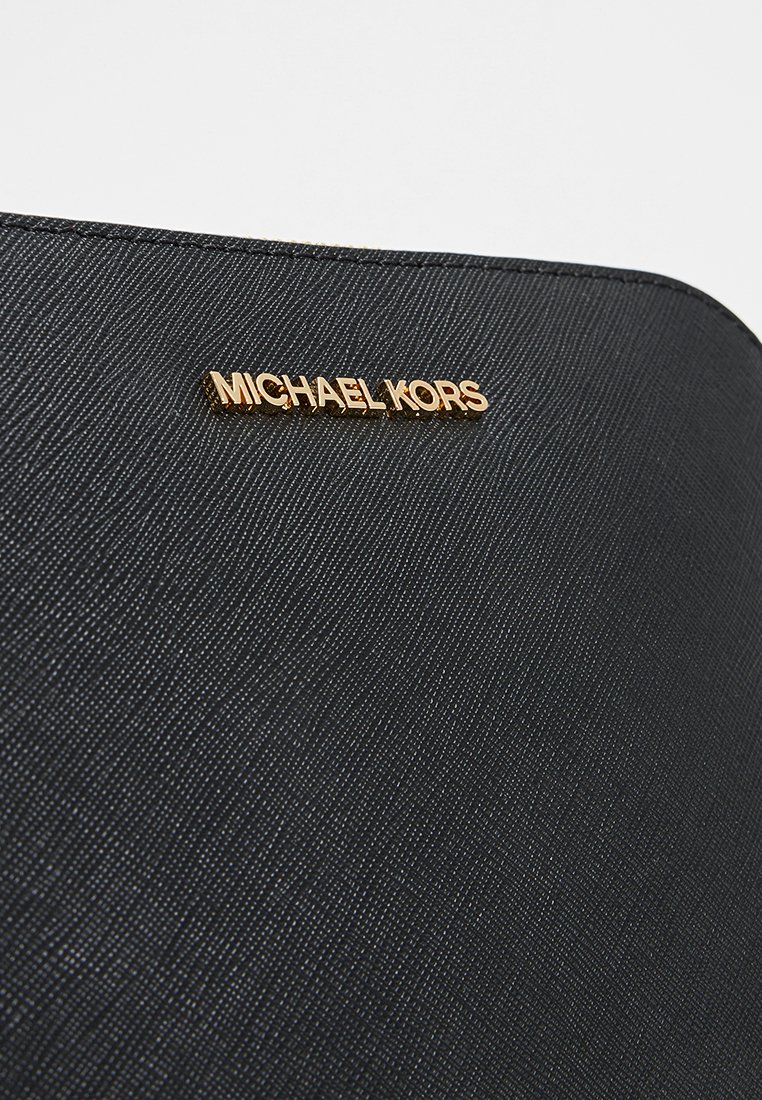 Schwarze handgefertigte Handtasche mit goldfarbener "MICHAEL KORS"-Logo. Das Design umfasst subtile Muster und eine elegante, strukturierte Form.
