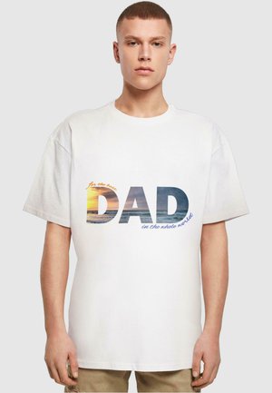 White cotton T-shirt featuring a graphic with the text "for the best DAD in the whole world," overlaying a beach sunset image.